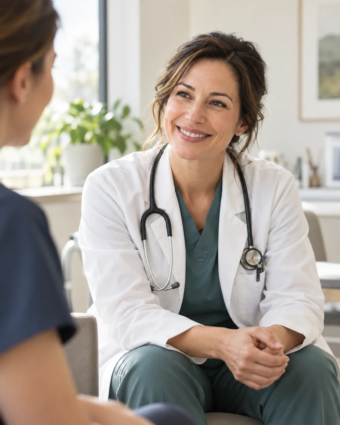 Physician smiling while talking with a patient in a bright clinic
